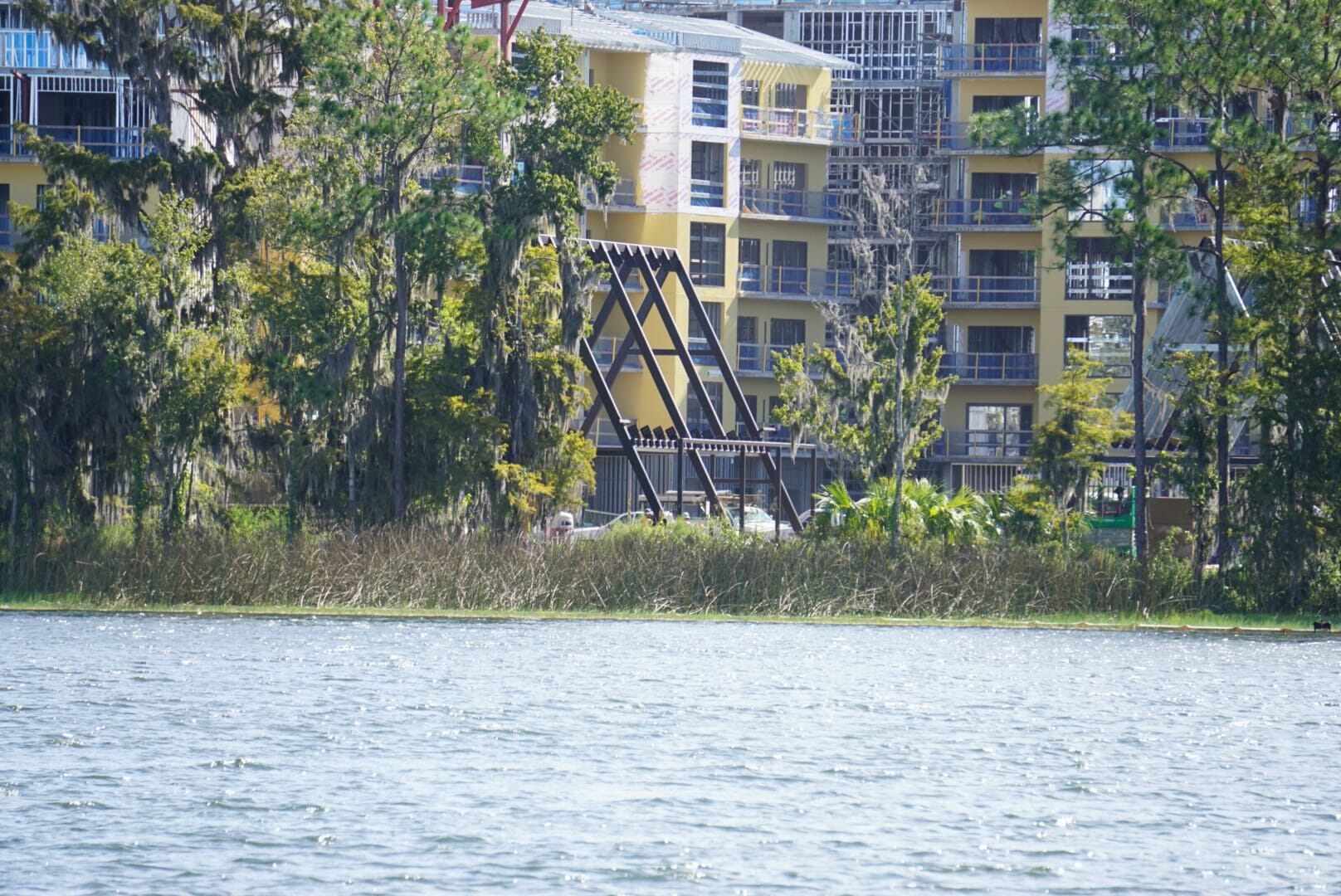 Apartment buildings and a metal footbridge behind trees and grass, unlike Disney park castles, form this peaceful Lakeshore Update scene. Apartment buildings and a metal footbridge behind trees and grass, unlike Disney park castles, form this peaceful Lakeshore Update scene.