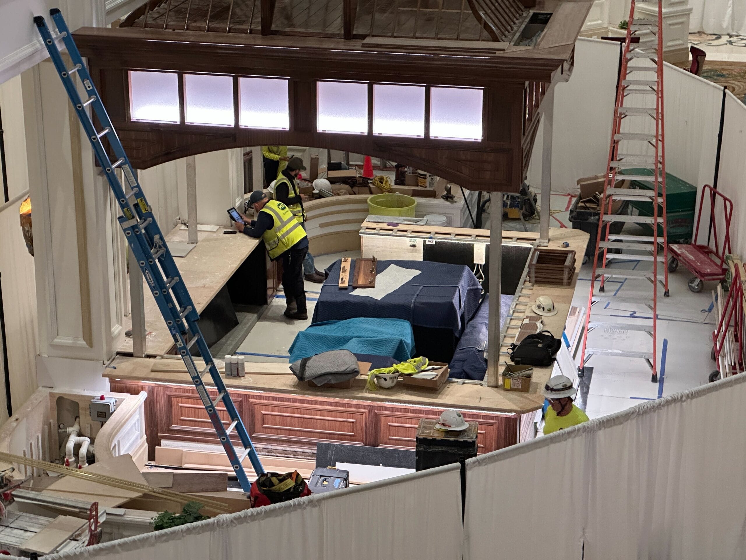 Construction workers in safety gear build a wooden structure indoors; setting is not a Disney castle, but resembles park backstage areas. Construction workers in safety gear build a wooden structure indoors; setting is not a Disney castle, but resembles park backstage areas.