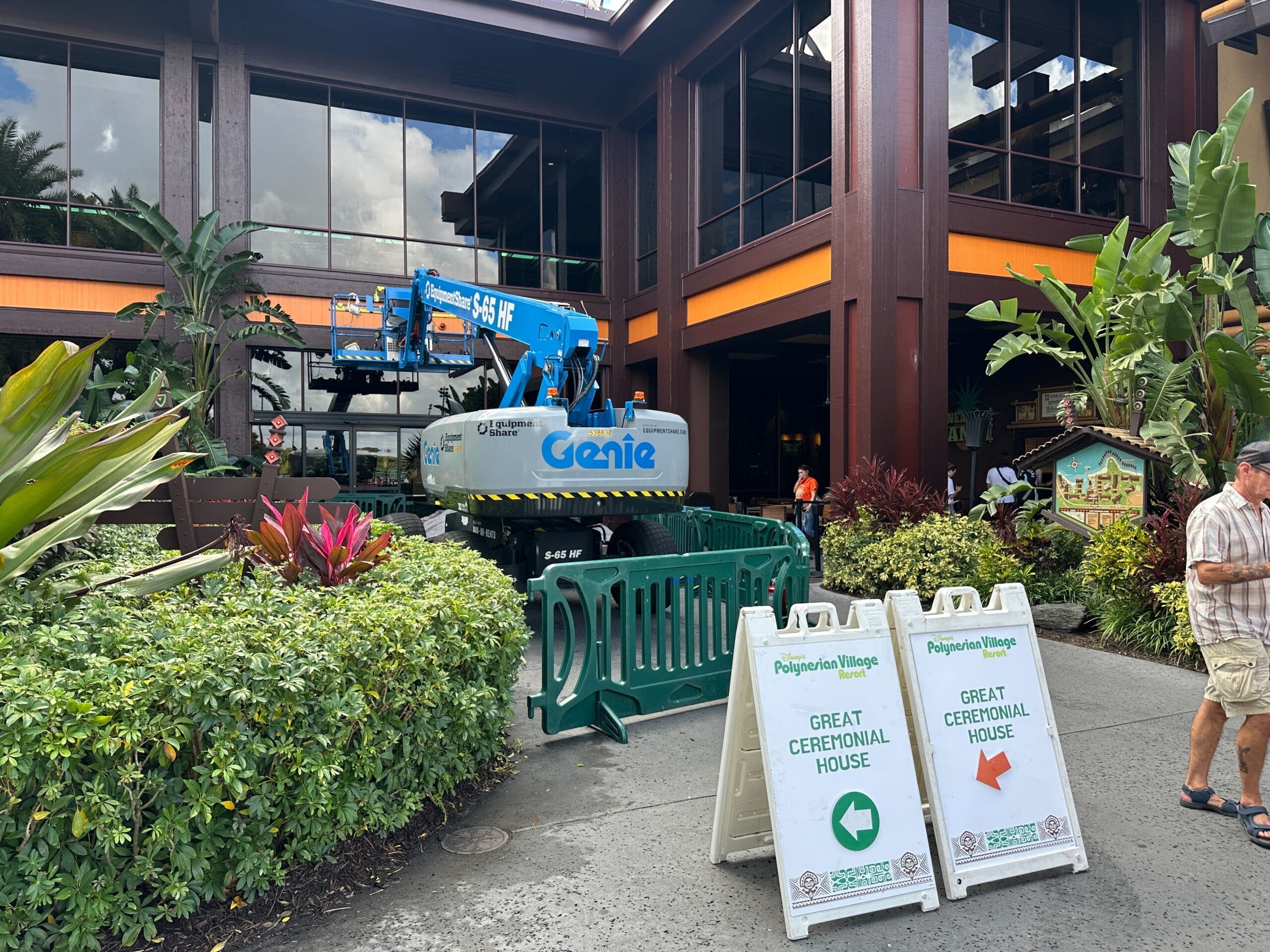 A blue Genie lift and barriers in front of a Polynesian-style building; signs direct guests to the Great Ceremonial House at Disney’s Polynesian Village Resort. A blue Genie lift and barriers in front of a Polynesian-style building; signs direct guests to the Great Ceremonial House at Disney’s Polynesian Village Resort.