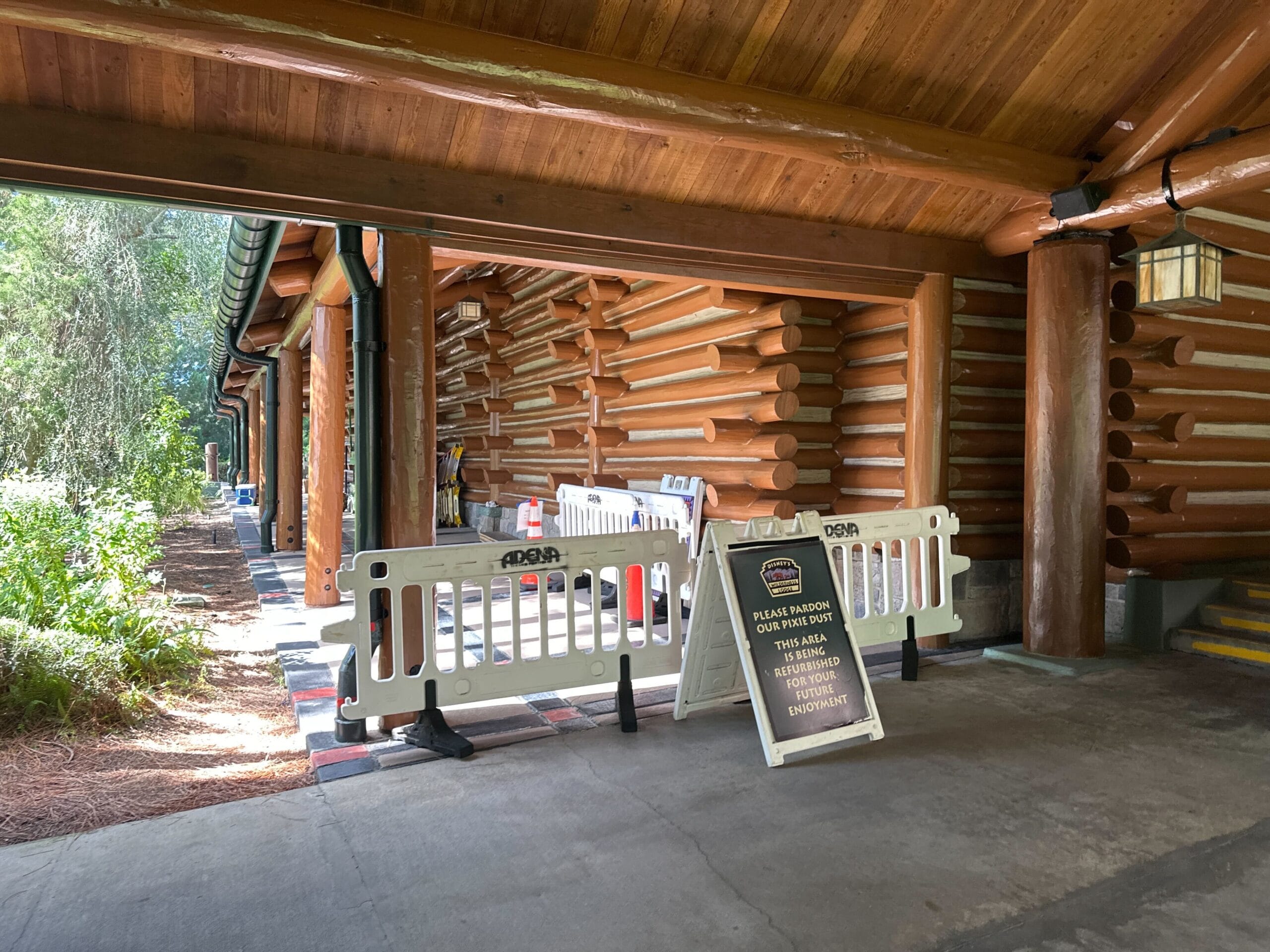 Log cabin at a Disney park with barriers and a closure sign, area off-limits for maintenance—no view of classic park castles here. Log cabin at a Disney park with barriers and a closure sign, area off-limits for maintenance—no view of classic park castles here.