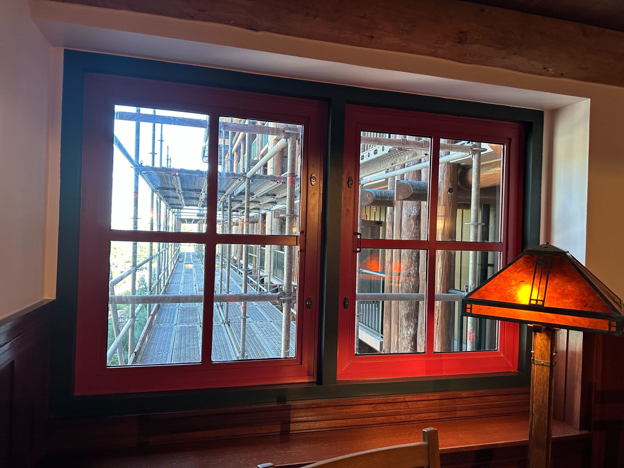Looking through a red-trimmed window—similar to Main Street facades at Disneyland—shows scaffolding outside, desk and lamp inside. Looking through a red-trimmed window—similar to Main Street facades at Disneyland—shows scaffolding outside, desk and lamp inside.